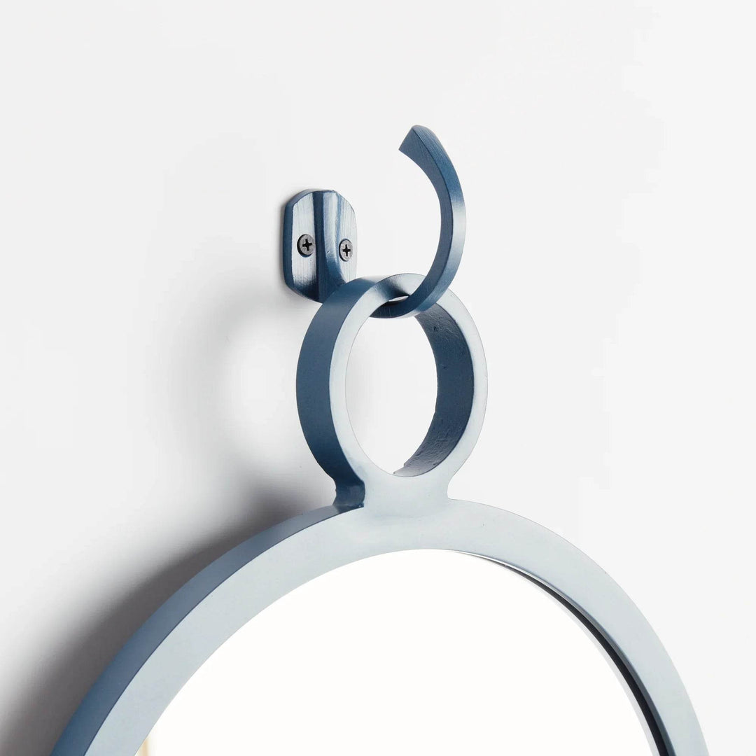 Close-up of hanging hook in matte blue finish on modern round mirror—perfect for coastal and minimal interiors