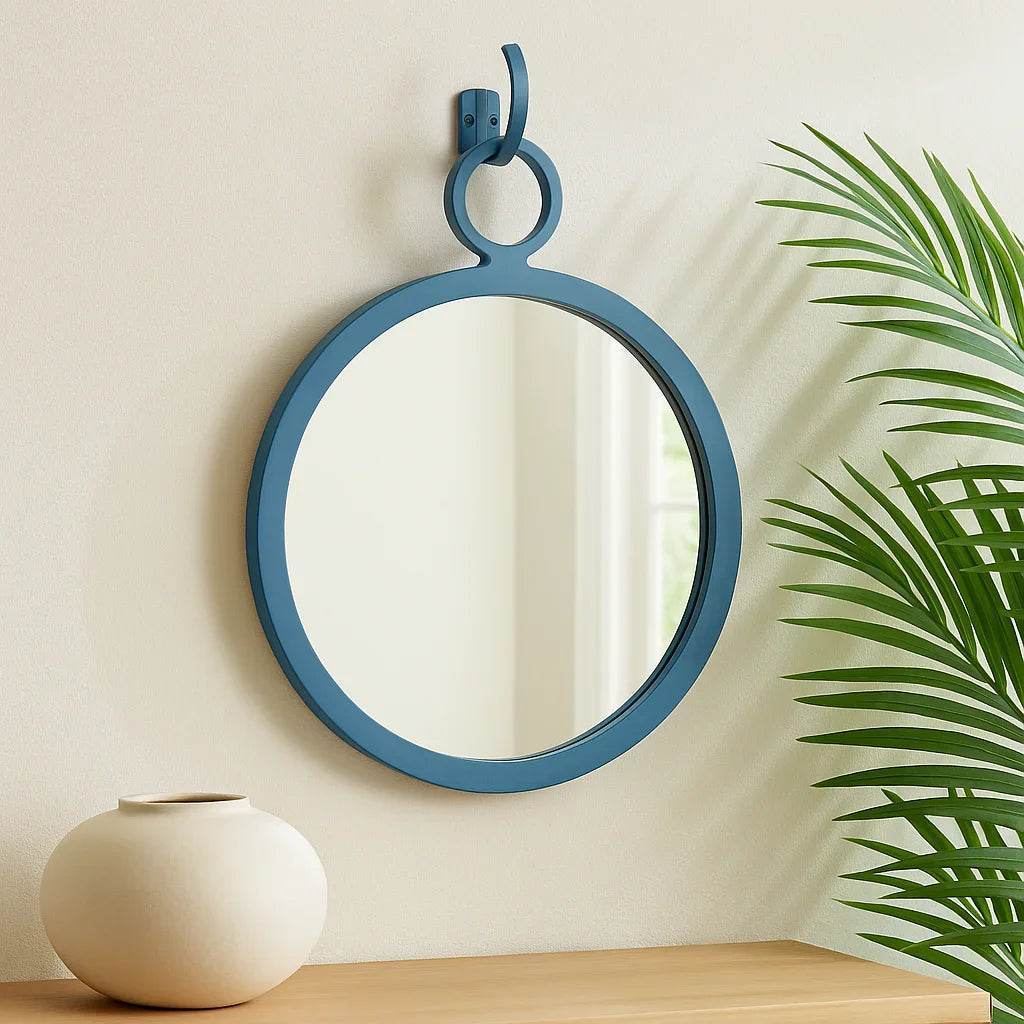 Minimalist round blue wall mirror featured in light coastal space with organic accents and soft neutral palette