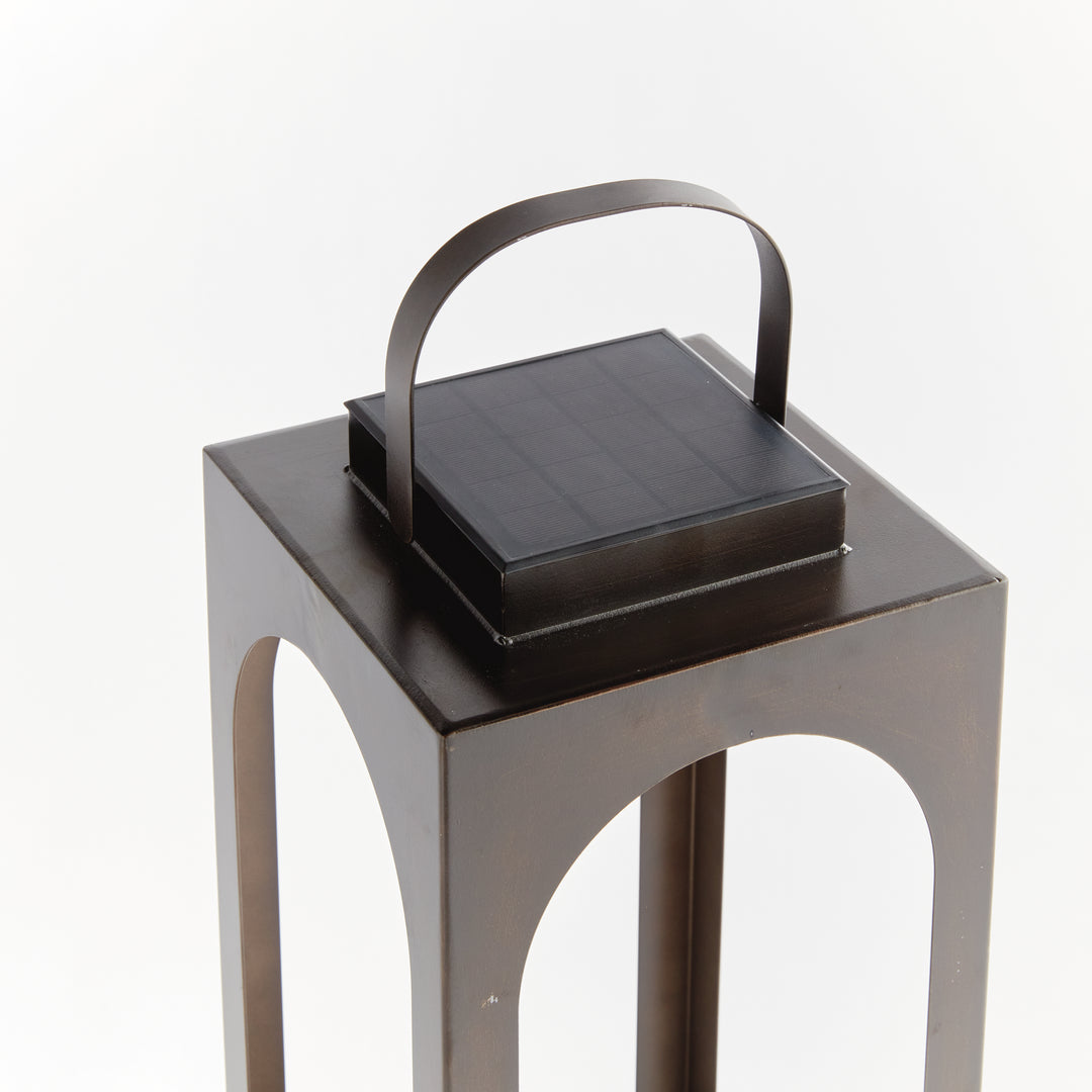 Close-up of the integrated solar panel and carry handle on a modern arched solar LED outdoor lantern – Transitional