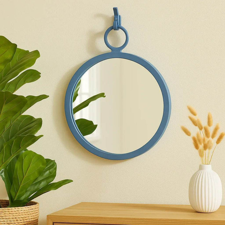 Round blue wall mirror styled above wood console—coastal modern decor with clean lines and natural textures