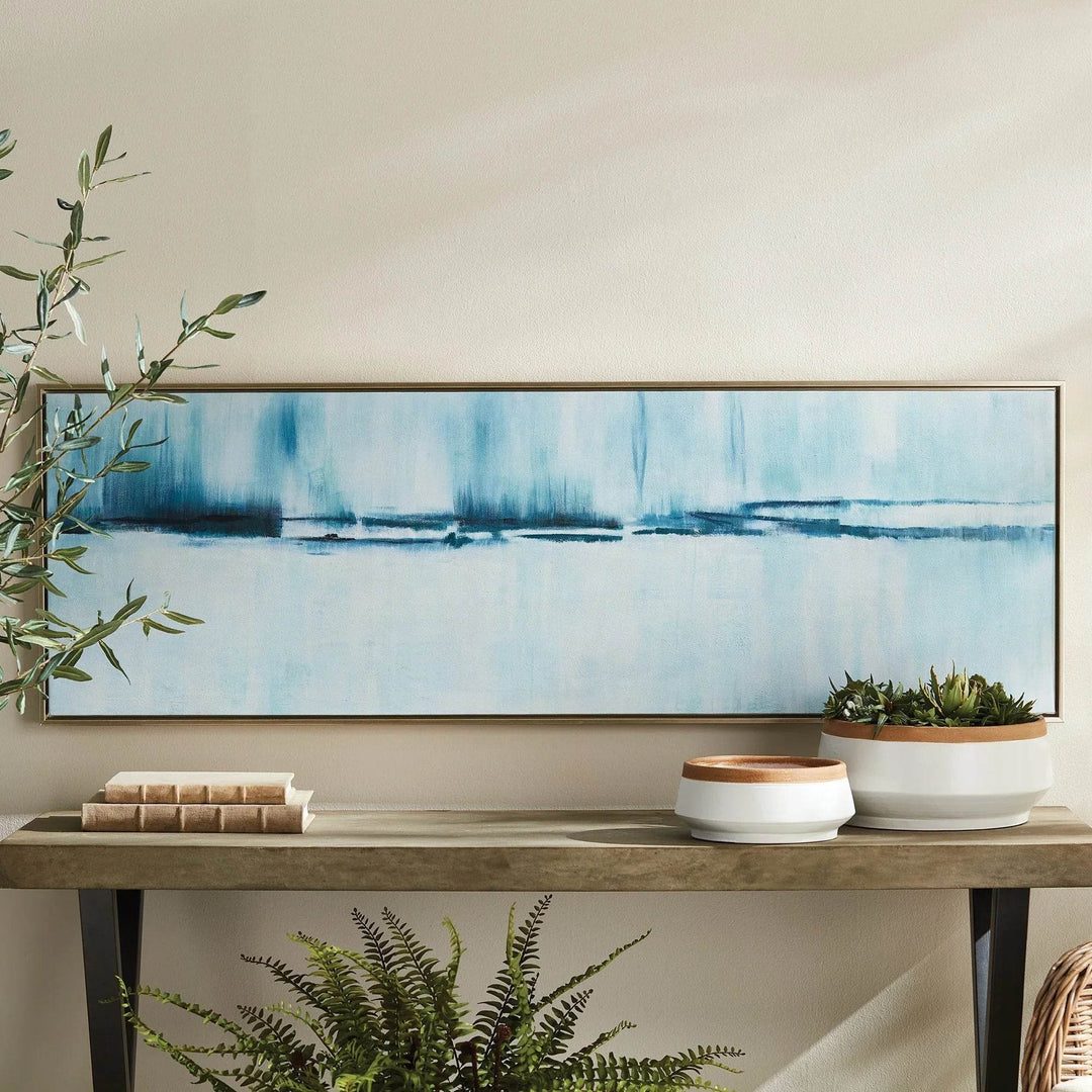 Modern coastal abstract artwork styled above console table in neutral entryway with minimal decor.

