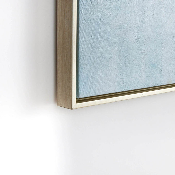 Detail view of light wood floating frame around canvas, showcasing modern coastal wall art construction.

