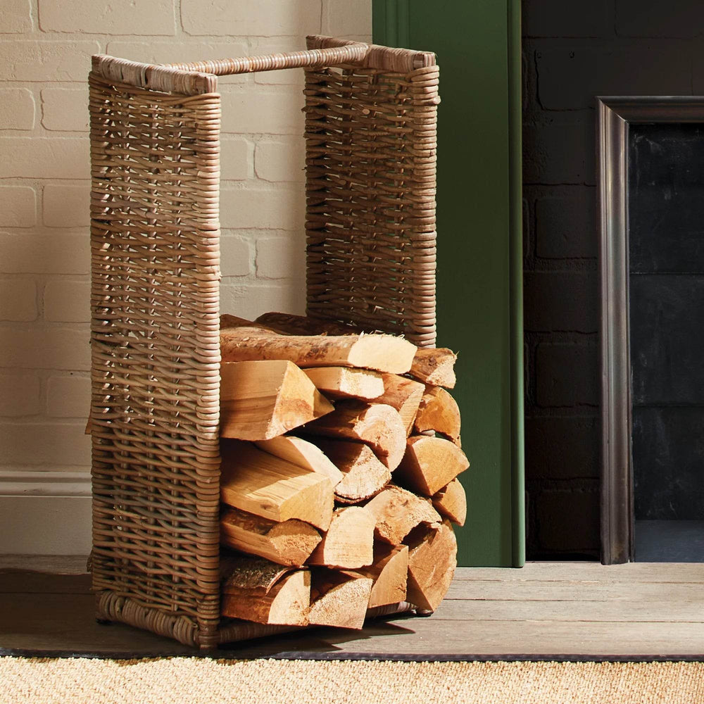 Woven rattan log basket styled beside fireplace with stacked wood, rustic modern farmhouse firewood holder