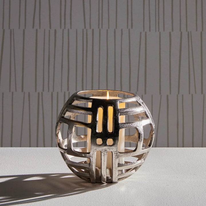 Medium modern industrial silver hurricane candle holder with cut-out design, styled with LED candle for console or table decor.

