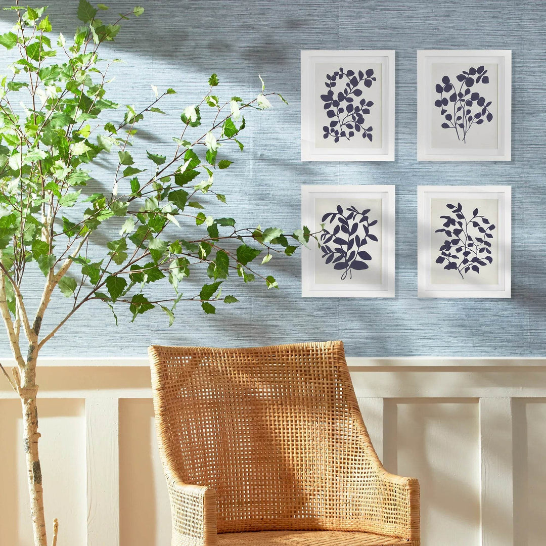 Modern navy botanical wall art set of four leaf prints in white frames.

