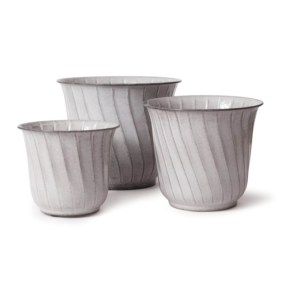 Set of three modern organic white metal planters with ribbed fluting, styled on white background, shown in various sizes.