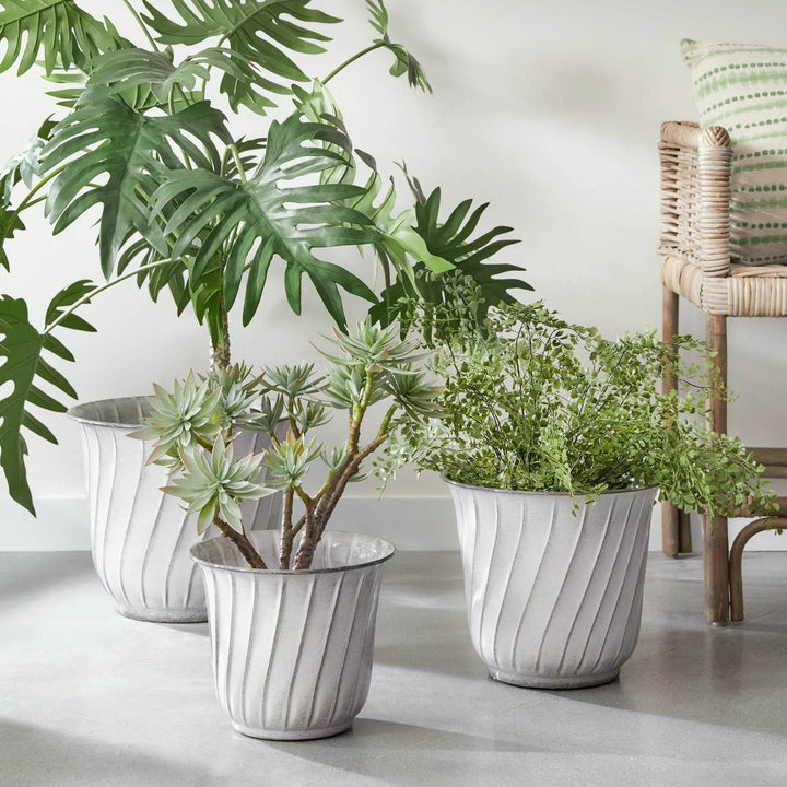 Modern organic white fluted metal planters with greenery, styled in a neutral garden setting with natural light.

