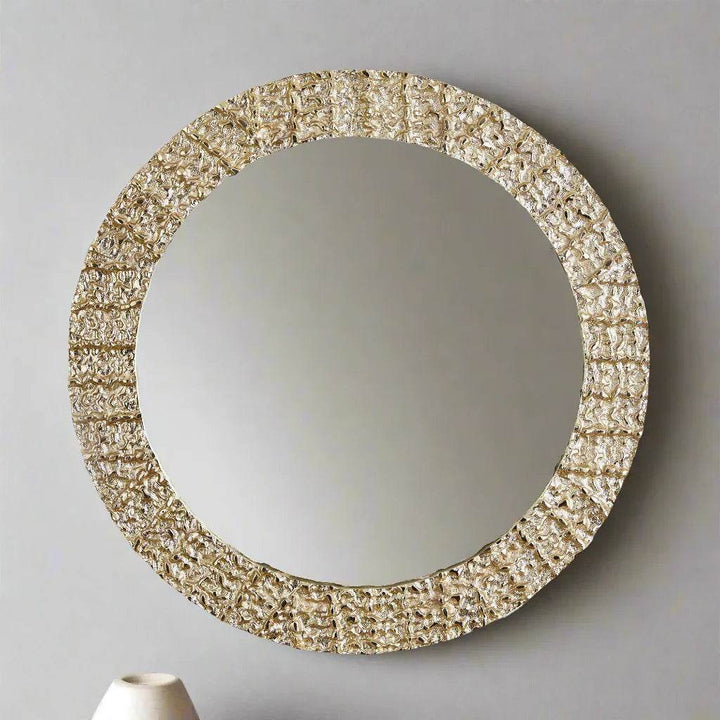 Angled side view of modern round wall mirror highlighting raised champagne-textured frame detail