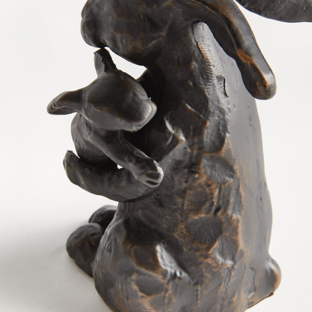 Full view of black mother rabbit sculpture holding baby, bronze undertone aluminum animal figurine, rustic decor