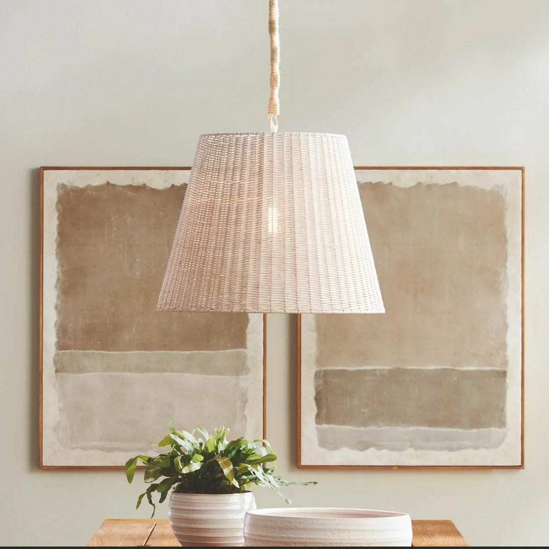 Natural rattan pendant light styled above a console with large framed artwork, greenery and a jute-wrapped chain in Coastal