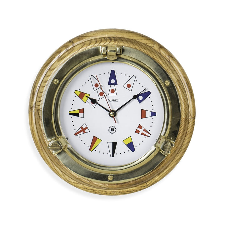Brass porthole wall clock with nautical flags dial shown angled front view for yacht office coastal decor style