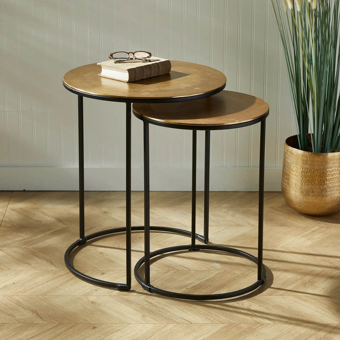 Urban organic side tables with book and glasses styled beside modern grass planter and golden pot.
