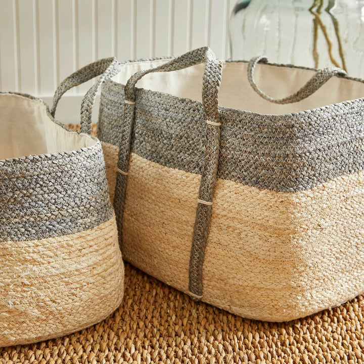 Neutral woven rectangular storage baskets in gray and beige tones, cotton liners and handles, for organized indoor home storage.

