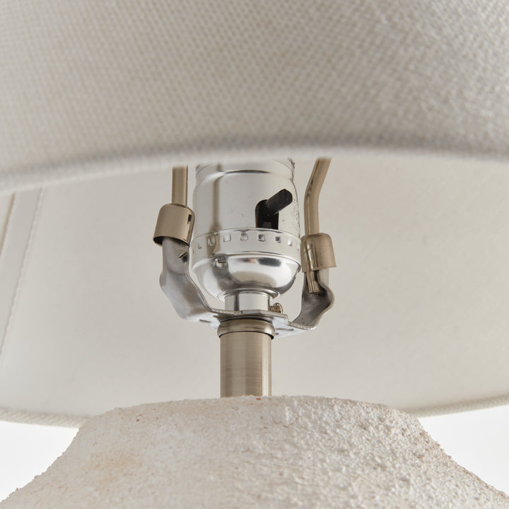 Orla table lamp socket and side switch beneath the linen shade, with metal supports above the ceramic body. Modern Organic