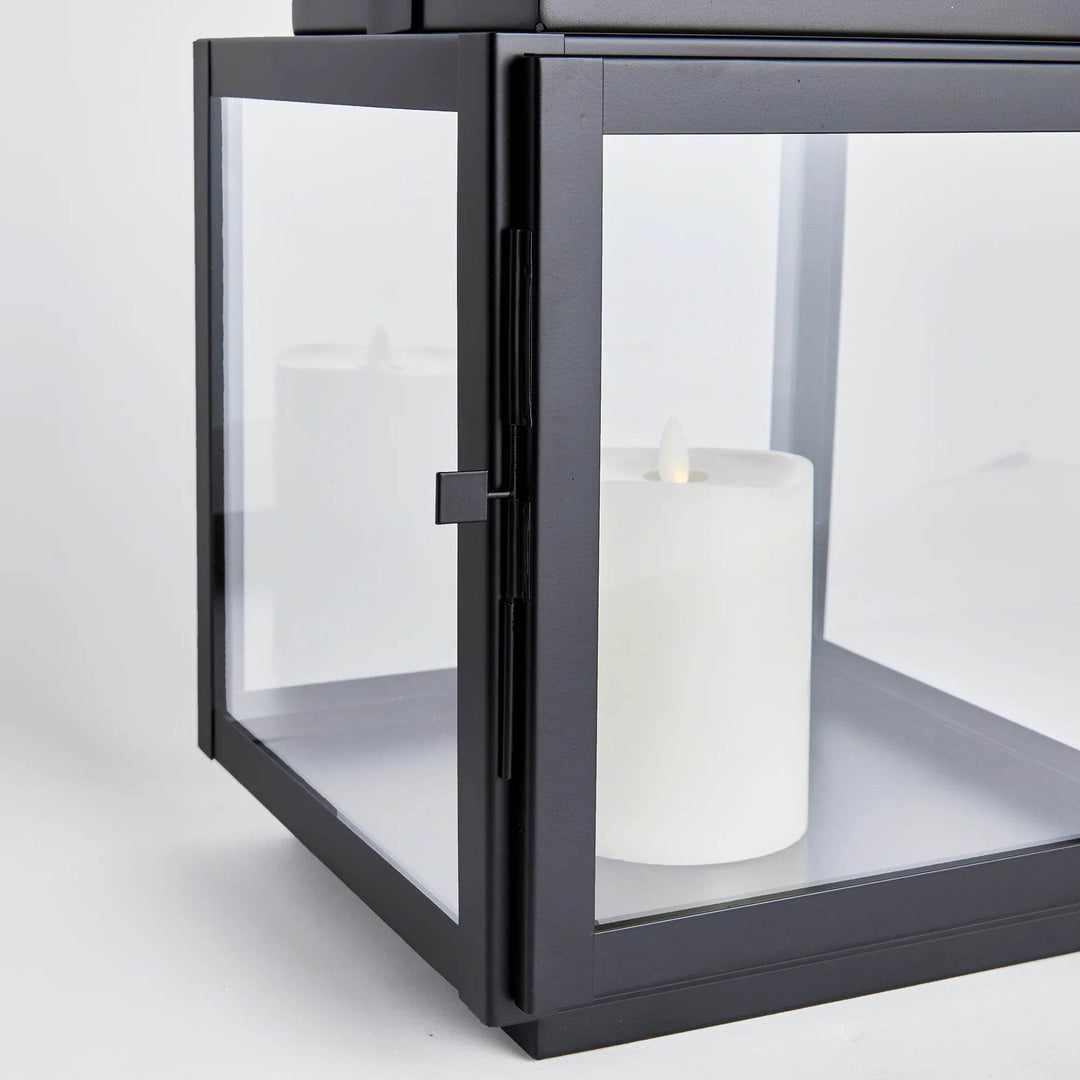 Close-up detail of medium outdoor lantern with wide glass panel and pillar candle inside