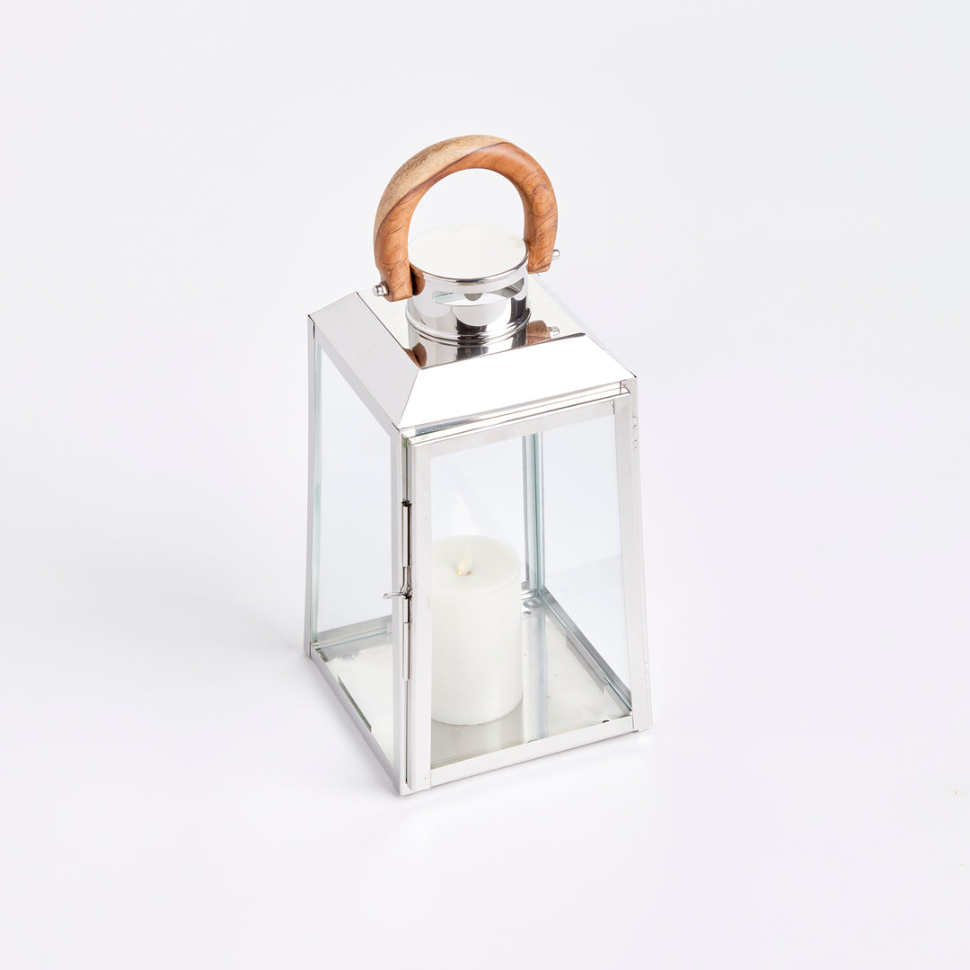 Small outdoor stainless steel lantern with clear glass panels and teak wood handle on white background coastal lantern