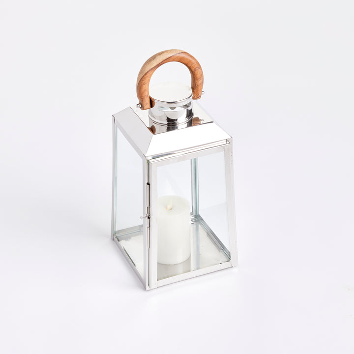 Small outdoor stainless steel lantern with clear glass panels and teak wood handle on white background coastal lantern