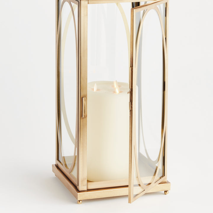 Brass oval frame candle lantern with glass panels and soft candlelight detail for transitional interior décor lantern