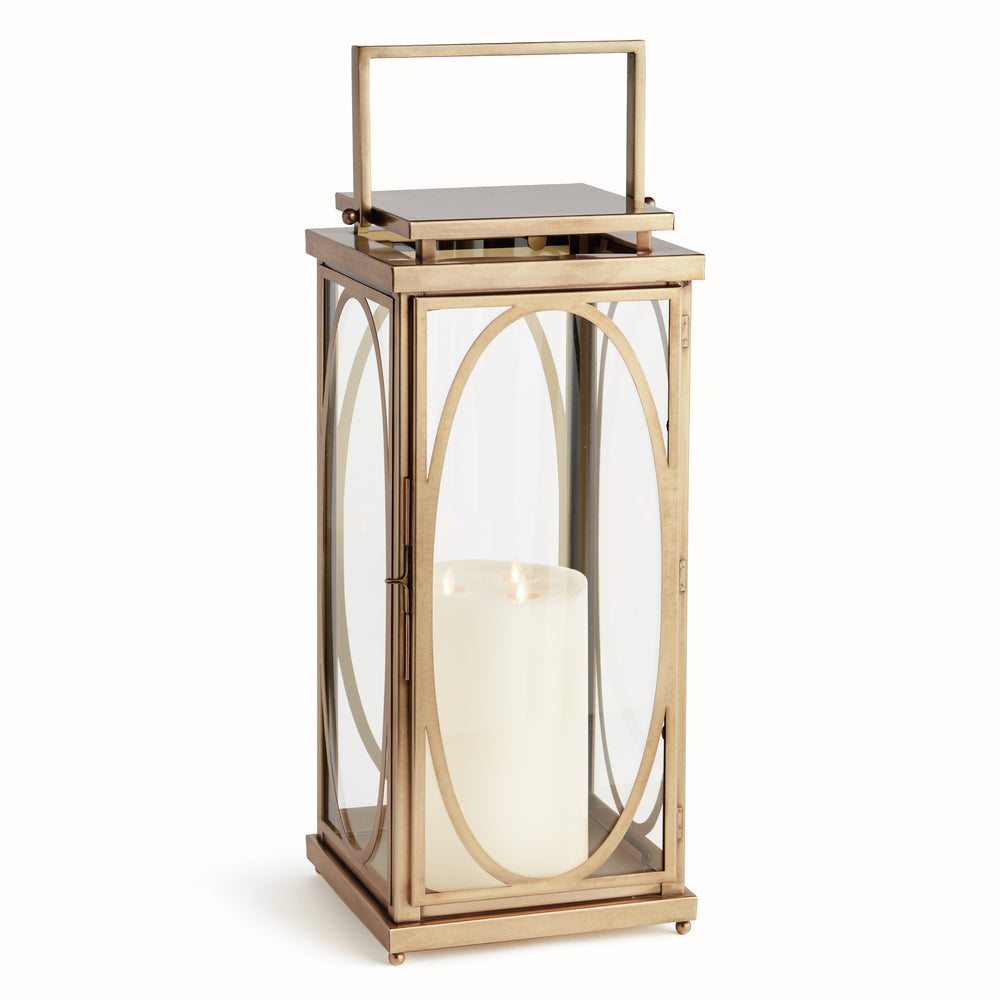 Large brass oval frame candle lantern styled on floor beside entryway for transitional architectural interior décor lantern