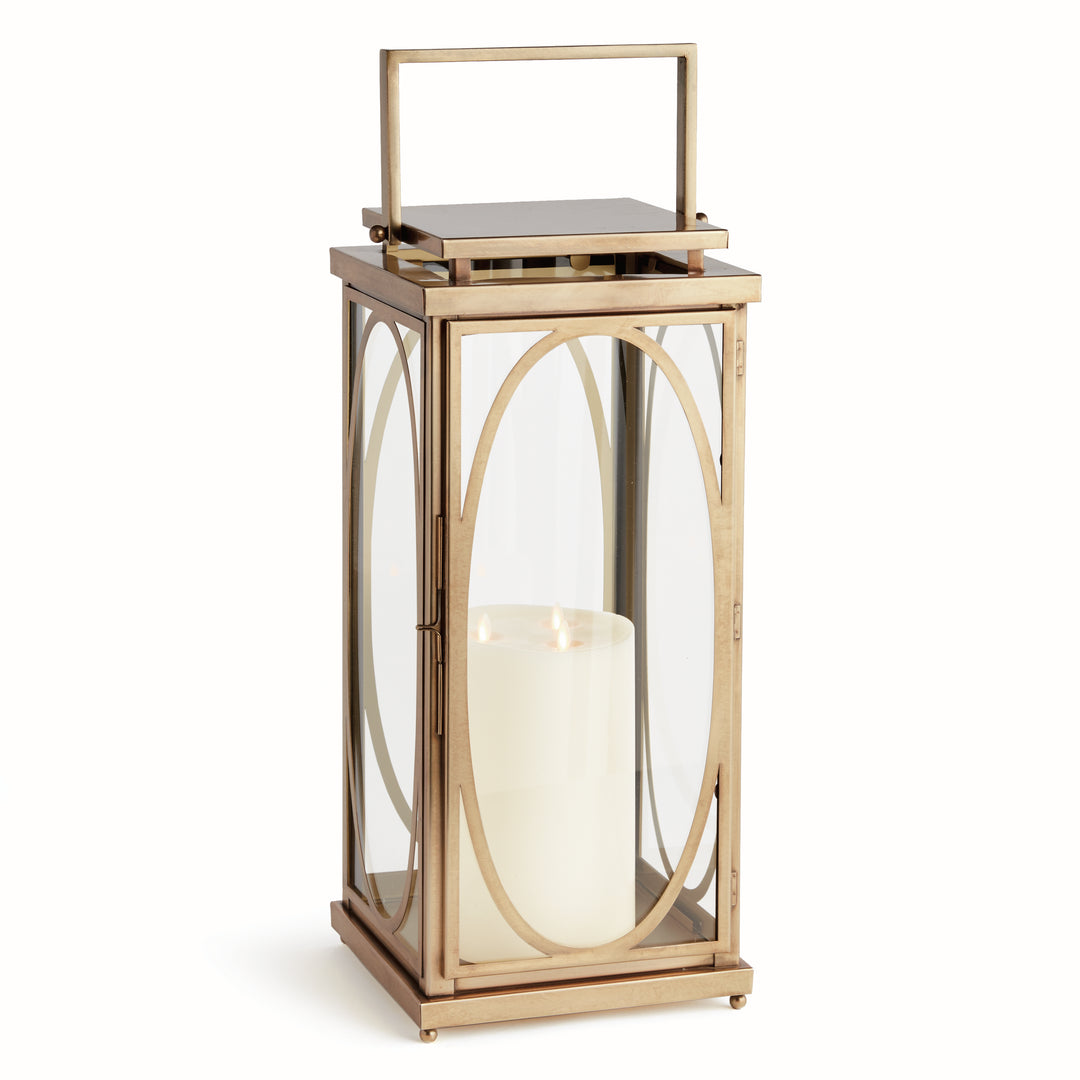 Large brass oval frame candle lantern styled on floor beside entryway for transitional architectural interior décor lantern