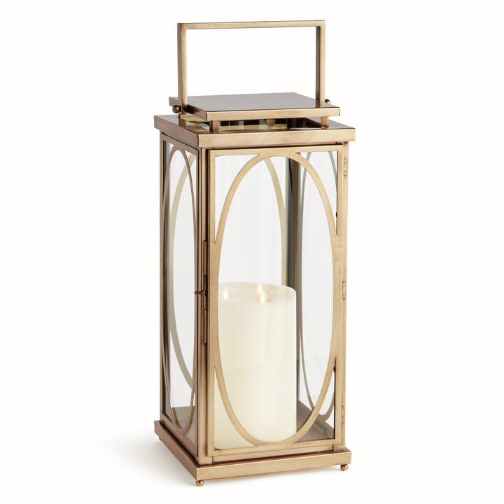 Large brass oval frame candle lantern styled on floor beside entryway for transitional architectural interior décor lantern