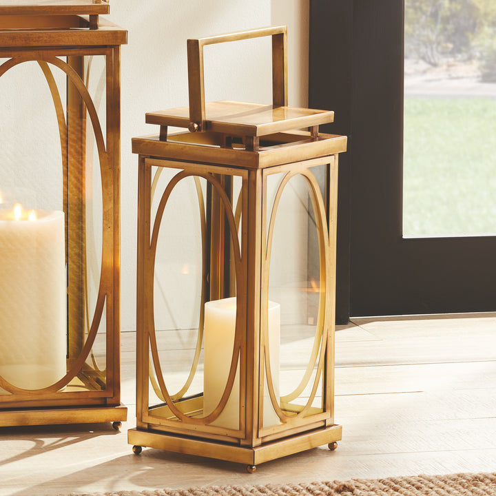 Brass oval frame candle lanterns styled together beside entryway for layered transitional interior décor lantern