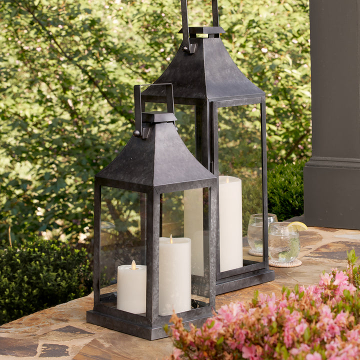 Oversized galvanized metal lanterns styled on outdoor patio with candles for industrial exterior decor style