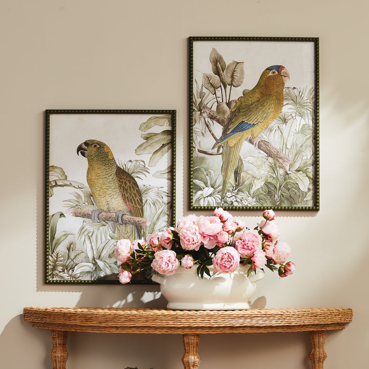 Tropical parrot prints displayed above a wood console with pink floral arrangement, in olive green beaded frames. Traditional