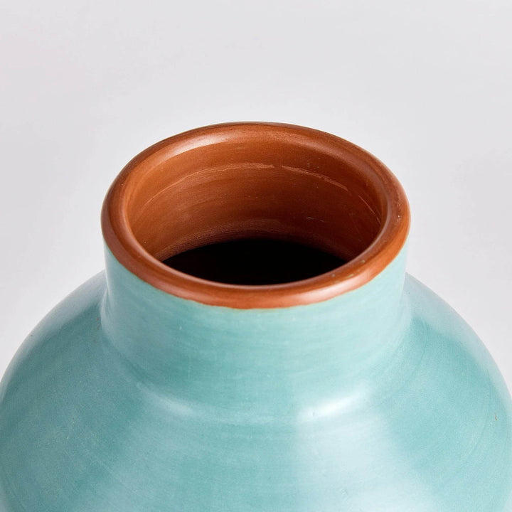 Closeup of vase rim showing natural clay interior and smooth pastel blue exterior, handcrafted detail

