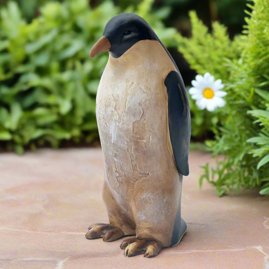 8.5" Penguin Sculpture Displayed on Stone Surface with Daisy and Green Garden Background