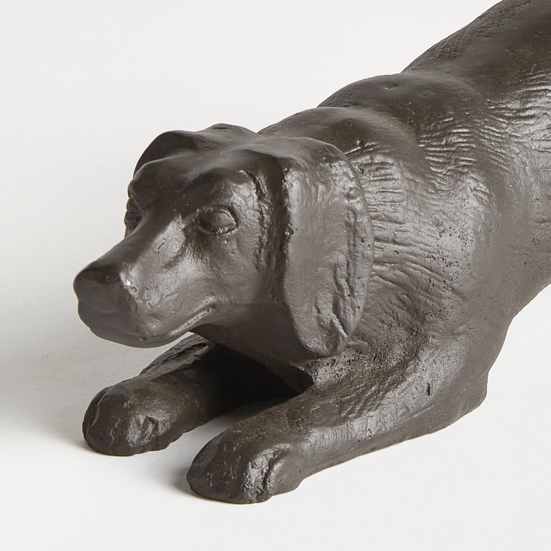 Front view of black playful dog sculpture in cast aluminum showing expressive pose and sculpted detailing.