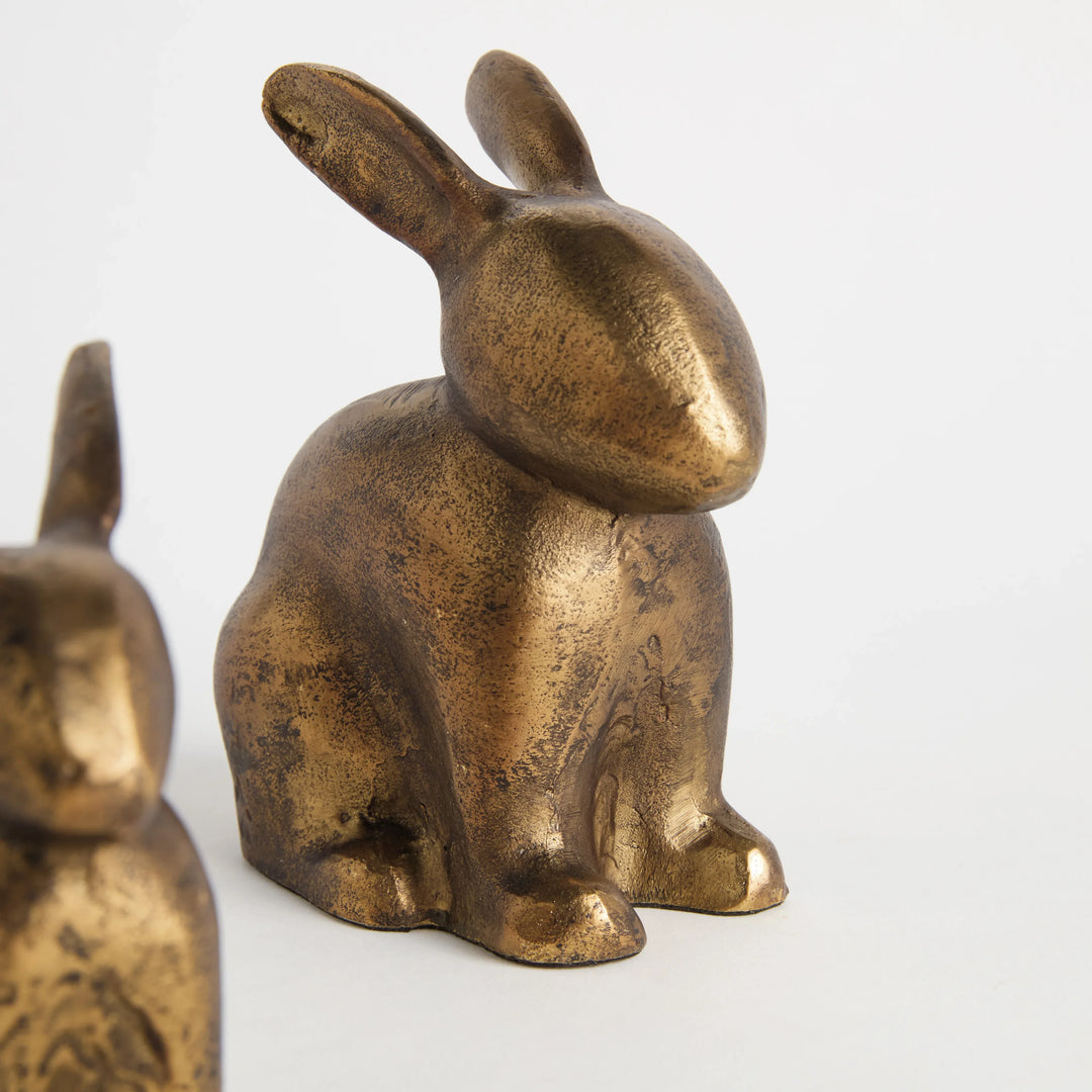 Closeup of antique brass rabbit sculpture set showing textured aluminum finish and seated decorative forms Traditional Transitional style