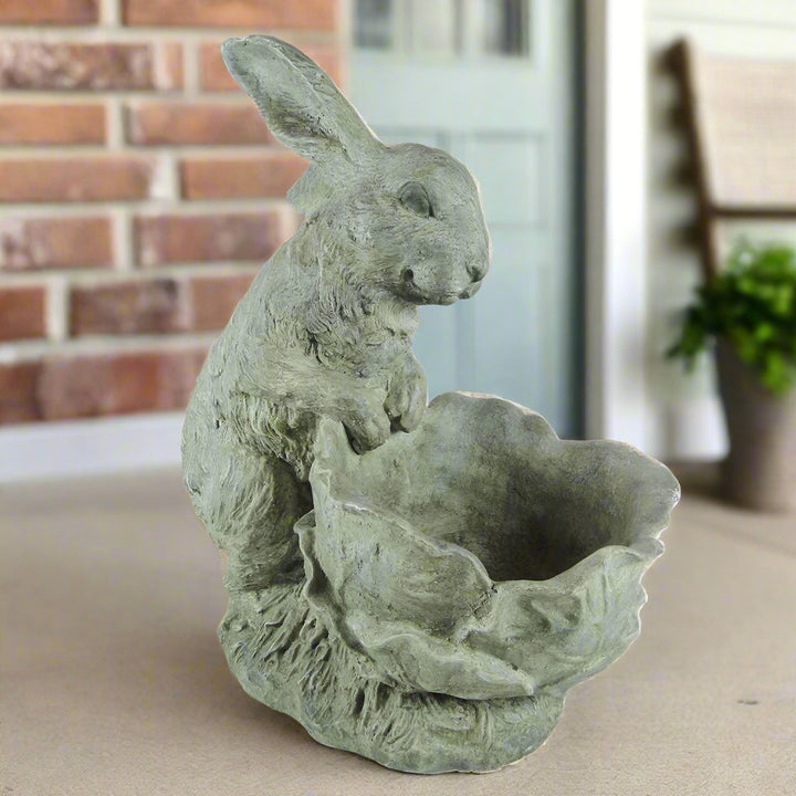 Bunny rabbit cement planter placed on a front porch with soft neutral tones and brick background

