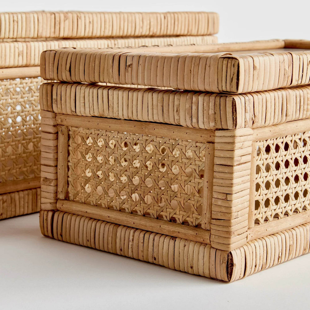 Close-up of stacked rattan display boxes showing wrapped corners, cane webbing panels, and raised bases for airflow – Coastal