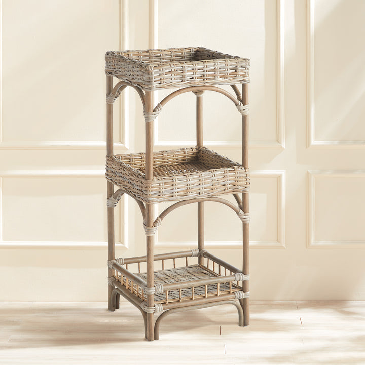 Woven rattan tiered shelf styled in a neutral room with paneling, showing its coastal boho utility.