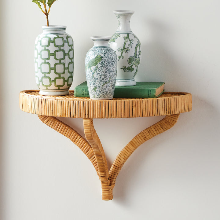 Wall-mounted rattan shelf styled with decorative vases and green books – Coastal styling inspiration