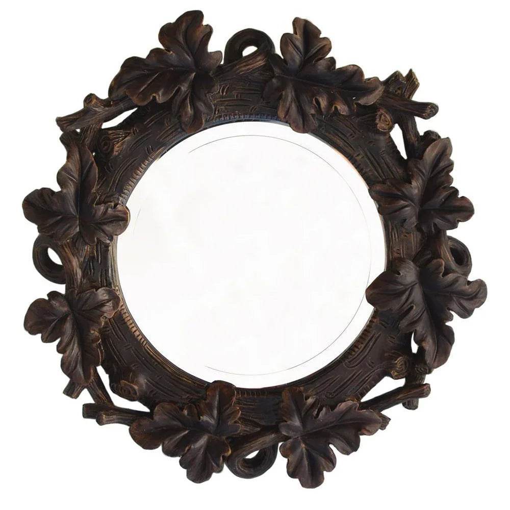 Close-up of round wall mirror with resin oak leaf frame in deep brown finish, perfect for lodge or cabin wall decor.