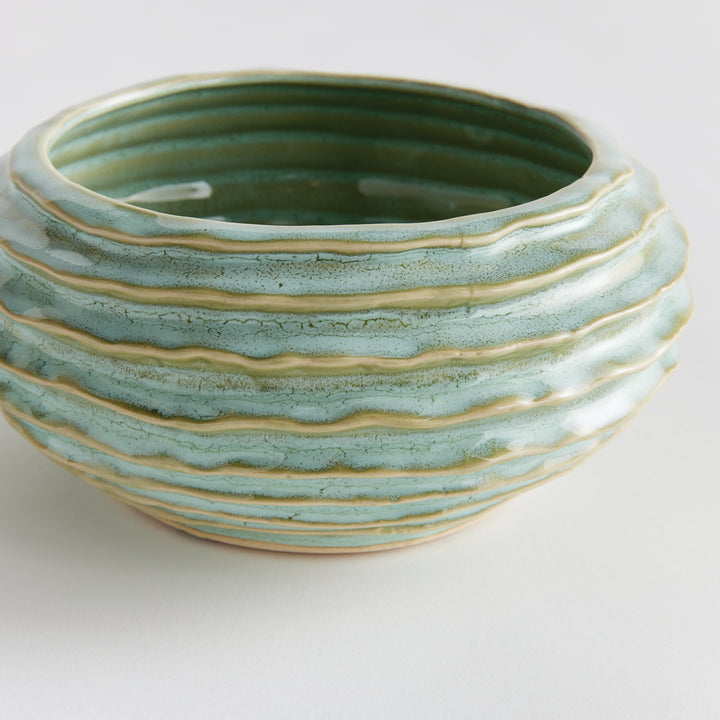 Close view of sage green decorative ceramic bowl with horizontal ribs pale edges and reactive glaze on white - Modern Organic