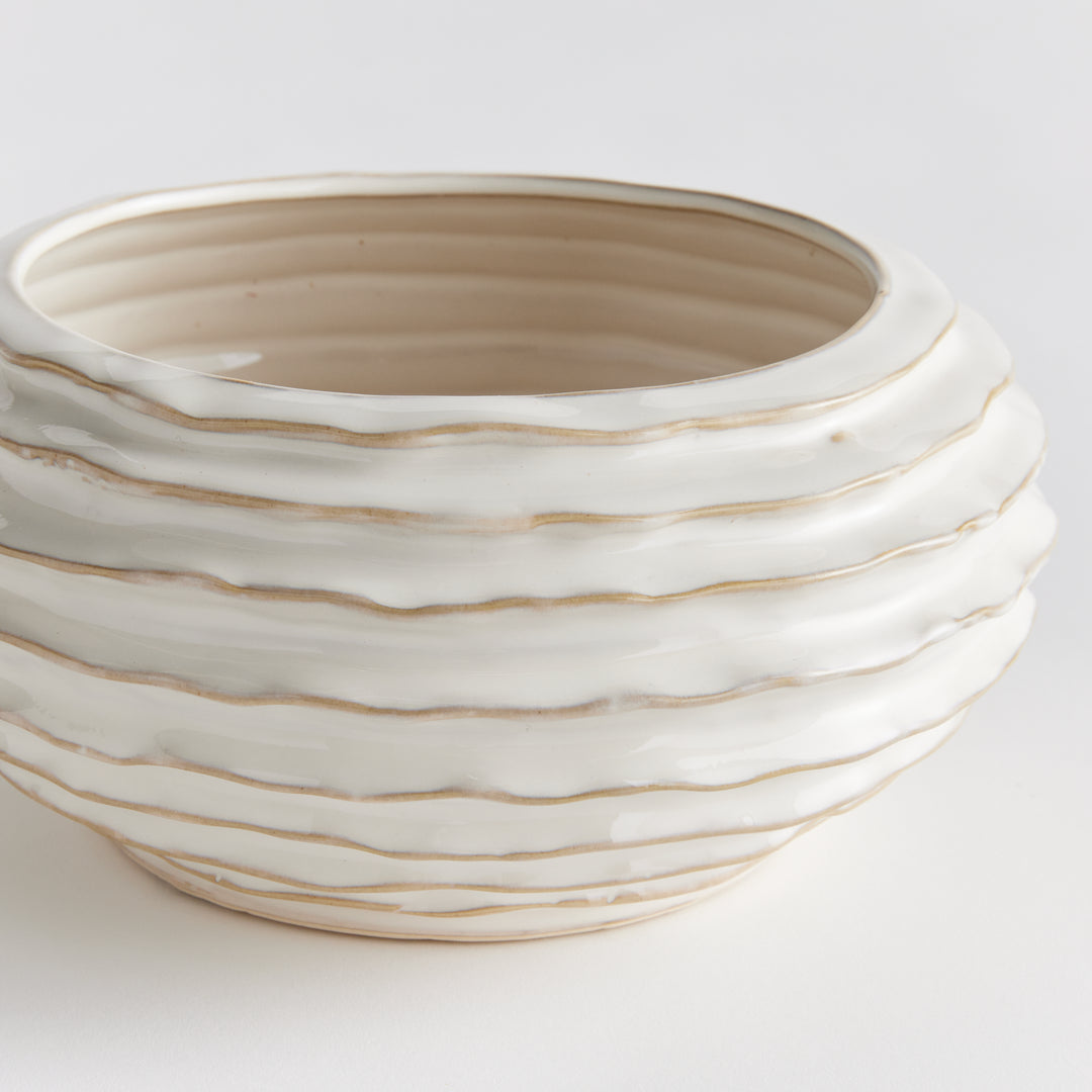 Close view of white ribbed ceramic decorative bowl with warm-toned ridges and glossy reactive-glaze surface - Modern Organic