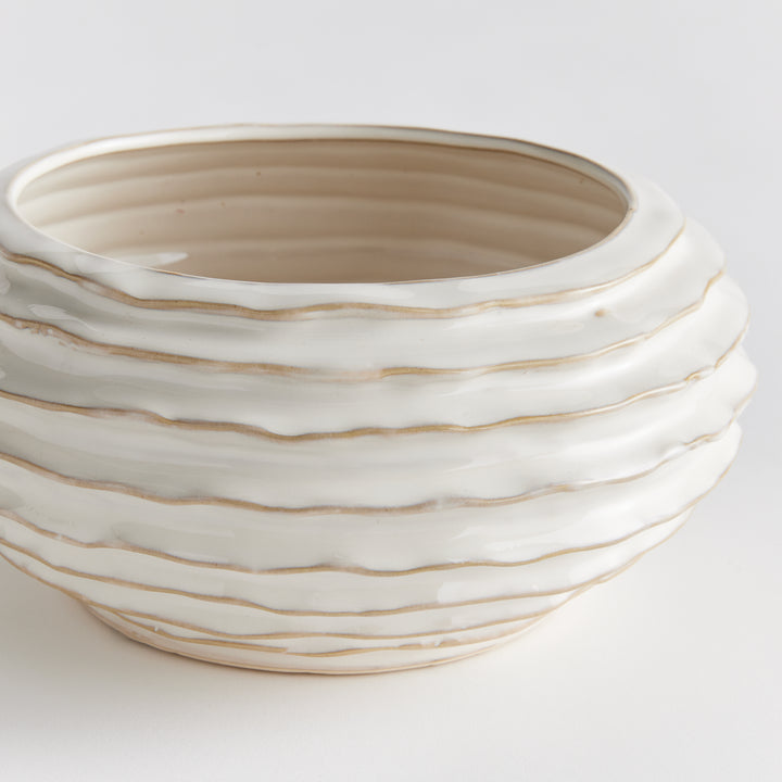 Close view of white ribbed ceramic decorative bowl with warm-toned ridges and glossy reactive-glaze surface - Modern Organic