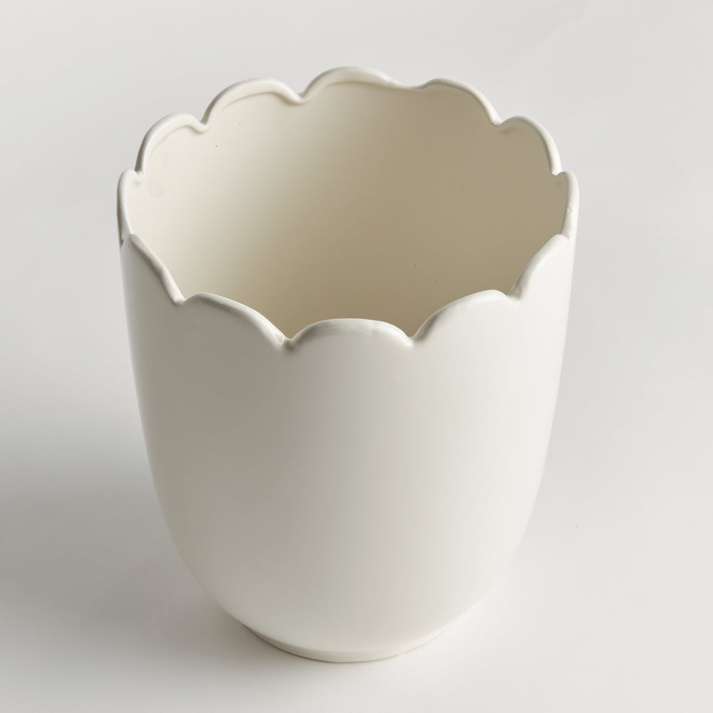 Angled view of a white clay cachepot showing its scalloped rim, curved sides and pale interior on a display | Traditional