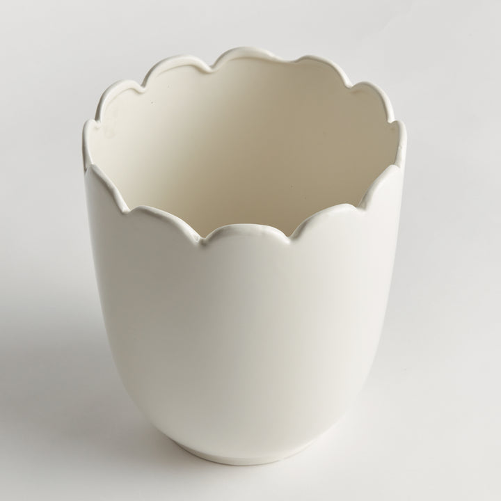 Angled view of a white clay cachepot showing its scalloped rim, curved sides and pale interior on a display | Traditional