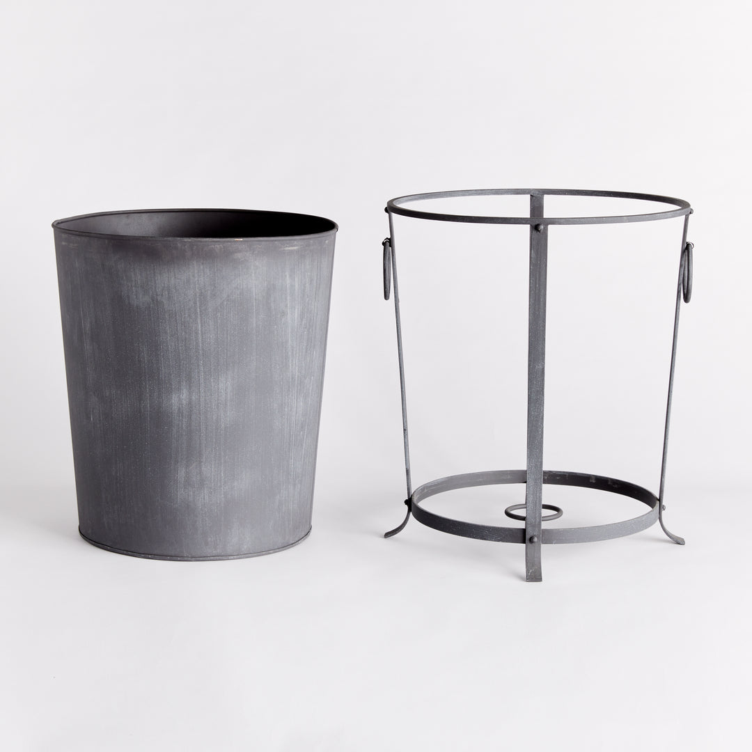 Large iron planter with its removable liner lifted out beside the support frame and ring handles. Industrial Transitional
