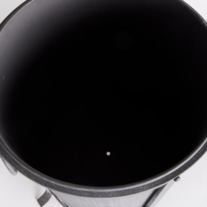 Medium iron planter viewed from above, showing the dark inner liner and drainage opening at its base. Industrial Transitional