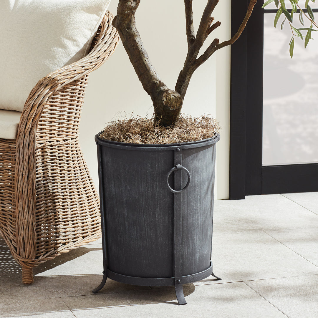 Medium iron planter styled with a tree within the top rim, showing its ring handles and raised round frame. Transitional