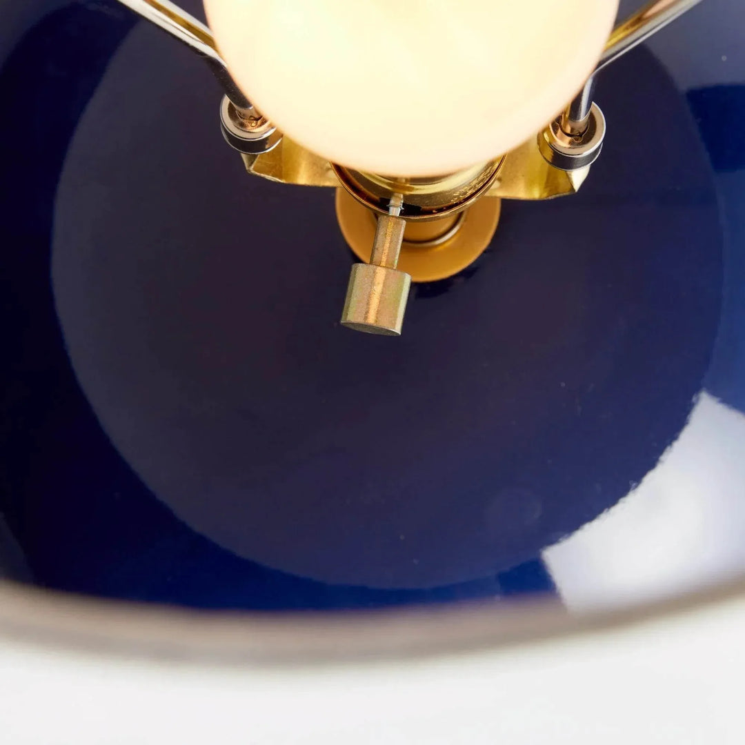 Detail of the rotary socket switch and illuminated bulb above the glossy blue glazed ceramic table lamp base. Transitional
