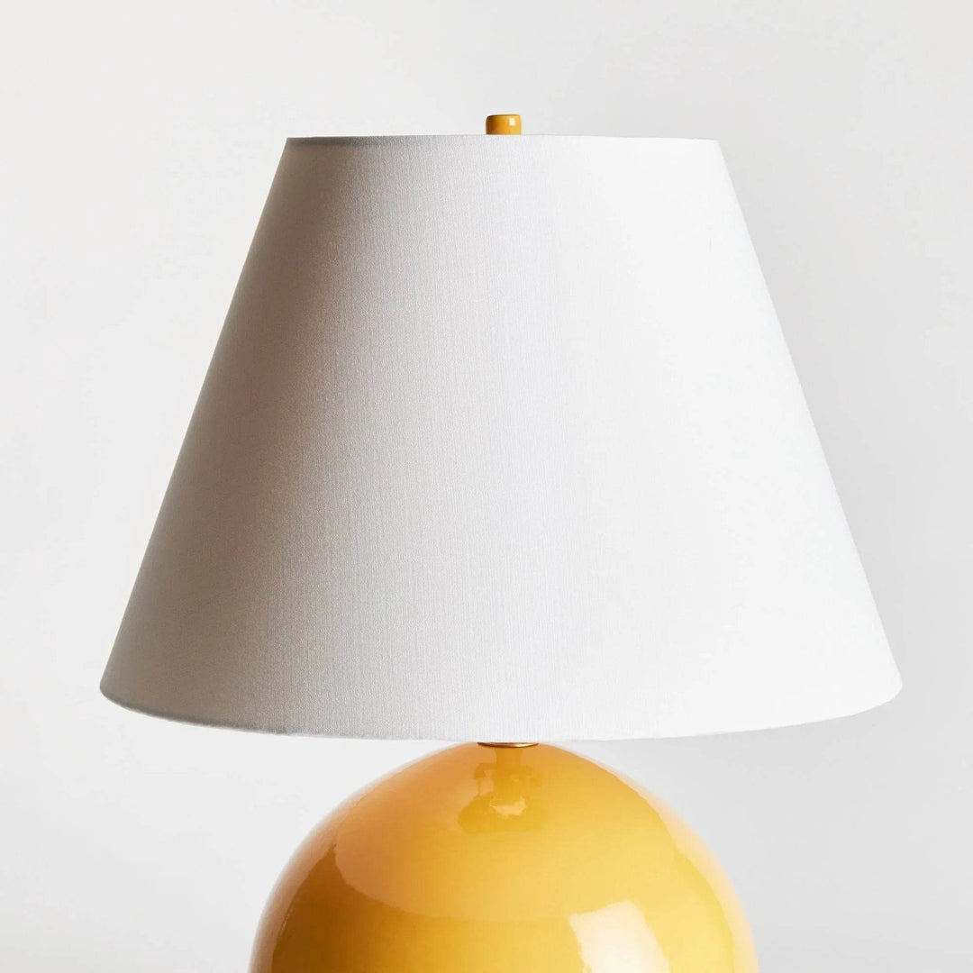 Detail of the white linen empire shade above the rounded marigold ceramic base, showing the tapered profile. Transitional