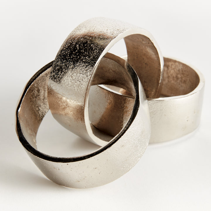 Close view of silver chain-link sculpture showing overlapping round links, textured aluminum and broad bands - Modern Organic
