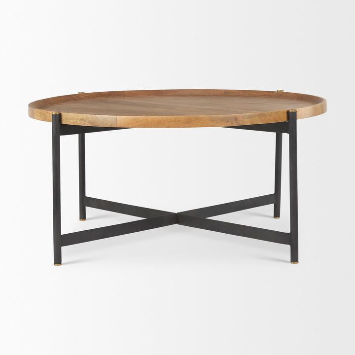 Angled view of round coffee table with solid mango wood top and cross-bar iron base – Modern Organic