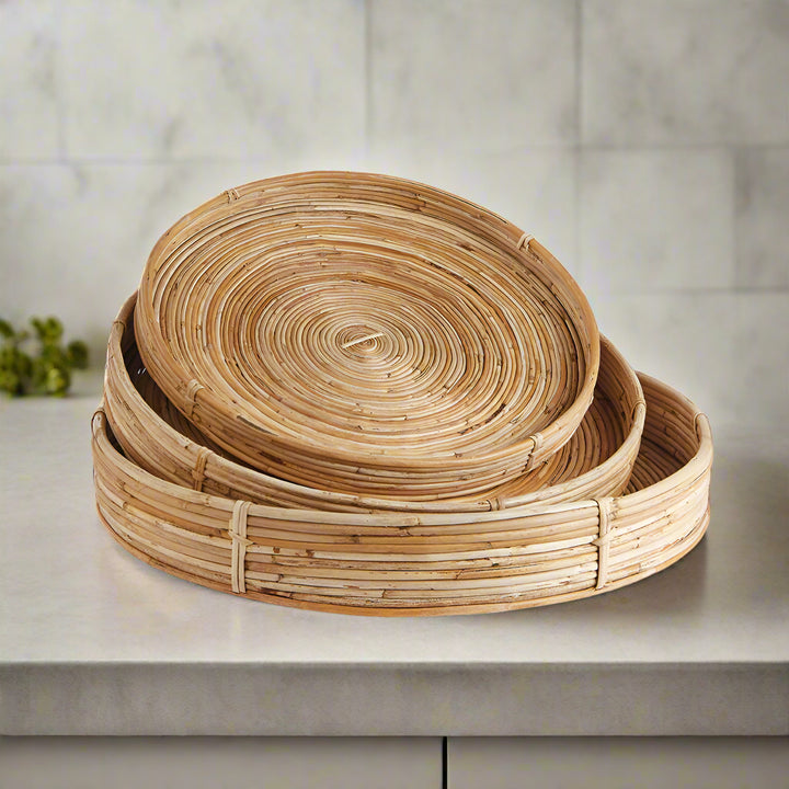 Side view of round rattan trays stacked together on neutral surface - boho natural wall decor